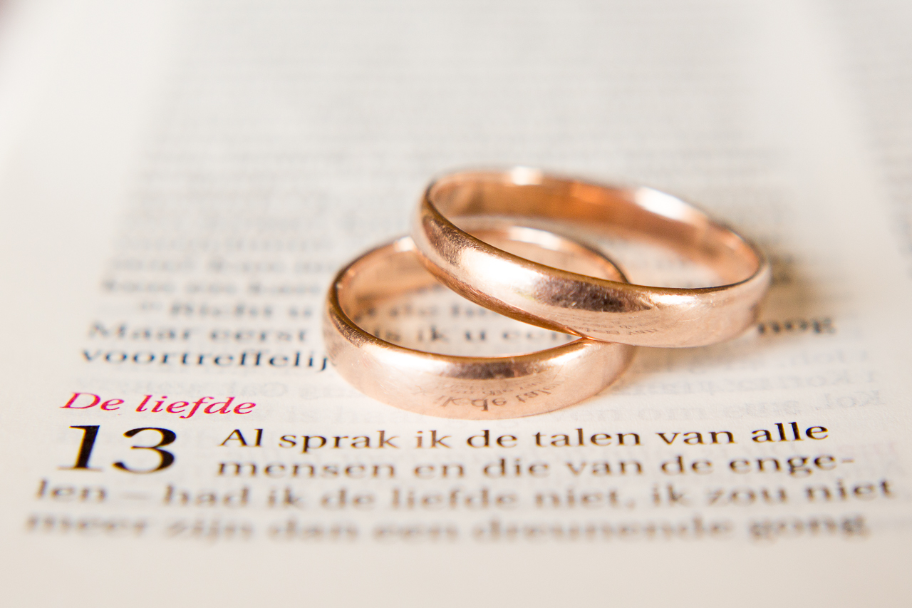 trouwringen op bijbel met trouwtekst de liefde
