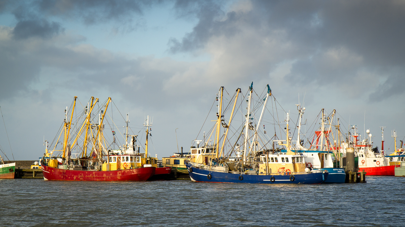Woeste luchten boven vissersschepen haven Lauwersoog